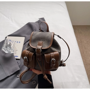 Detail of vintage canvas and leather backpack with flap pockets and drawstring closure