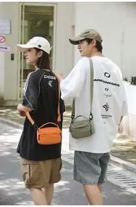 Street view of minimalist orange and olive green crossbody bags showing daily carrying style