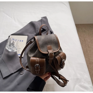 Detail of vintage gray canvas and brown leather backpack with metal buckle closures