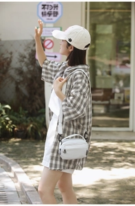 Lifestyle shot of a white nylon crossbody bag with adjustable strap and casual outfit