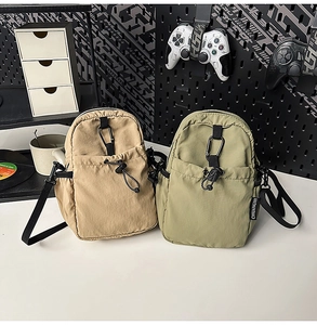Détail de sacs bandoulière en nylon kaki et olive avec poches à cordon et mousquetons