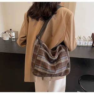 Dettaglio della borsa hobo a quadri marroni in tweed con ampia tracolla comoda