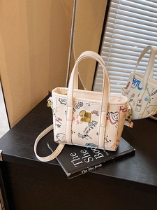Chic cream tote bag with cartoon graffiti print and adjustable strap for women