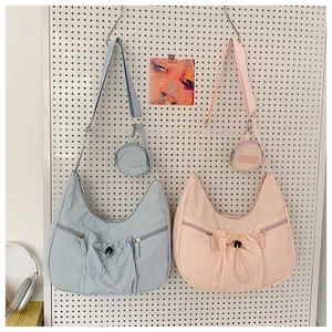Details von Nylon-Halbmondtaschen in Blau und Rosa mit Reißverschlusstaschen und Etuis