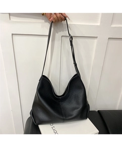 Detail of black pebbled leather texture on a spacious vintage hobo shoulder bag for women