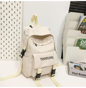 Close-up of cream canvas backpack with functional pockets and TIANFLONG logo print
