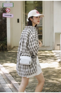 Chic beige crossbody bag with adjustable strap worn by model in an urban outdoor setting