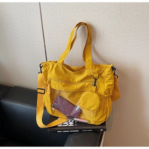 Detail of yellow nylon tote bag with transparent PVC pocket and round coin purse