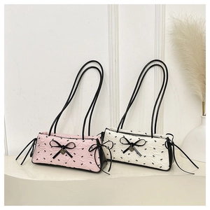 Detail of quilted bow shoulder bags in pink and white with heart pendant detail