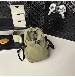Sac bandoulière en nylon vert olive avec poche à cordon et détail de mousqueton noir