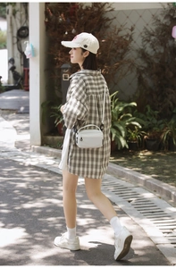 Close-up of oversized coffee and beige checkered long-sleeved shirt with classic collar