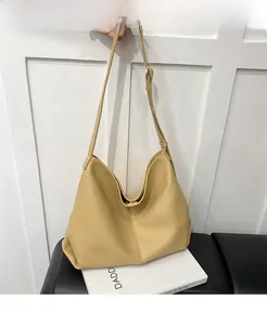 Close-up of yellow hobo bag in lychee pattern leather with wide shoulder strap