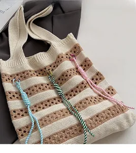 Detail of hollow knit tote bag featuring striped pattern and colorful twisted rope accents