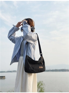 Detail of water-resistant black nylon crescent messenger bag with adjustable strap