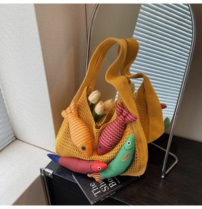 Detail of yellow knit hollow tote bag featuring colorful fabric fish ornaments