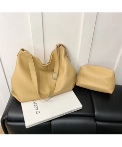 Detailed macro view of mustard yellow pebbled leather tote bag with matching zippered pouch