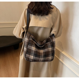 Borsa tote a quadri marrone indossata da una modella per mostrare dimensioni e stile