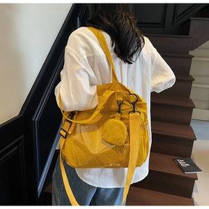Detail view of yellow canvas tote bag with front pocket and round accessory coin purse