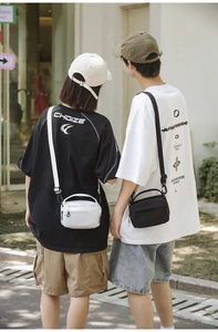 Detail view of black and white mini crossbody bags with adjustable straps and zipper