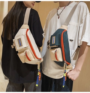 Détail des sacs de poitrine en toile avec bordure orange et pendentif visage souriant