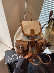 Vintage canvas and brown leather backpack with drawstring closure and buckle pockets