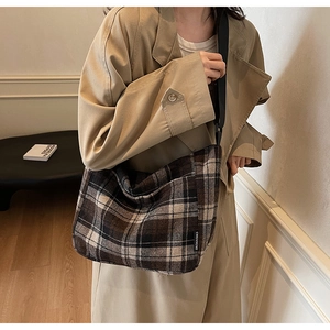 Dettaglio della borsa tote vintage a scacchi marroni indossata da una modella