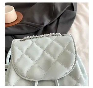 Detail of light blue quilted backpack showing the silver metal twist lock and chain handle