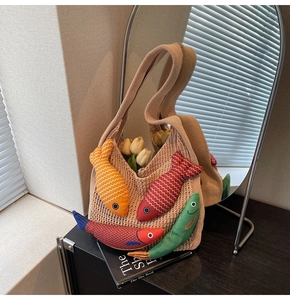 Detailed shot of beige knit tote bag with colorful fish charms and white tulips