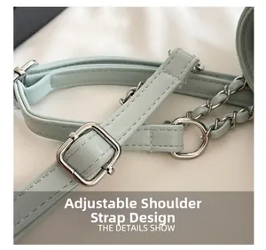 Detail of adjustable light blue faux leather strap with silver buckle and chain links