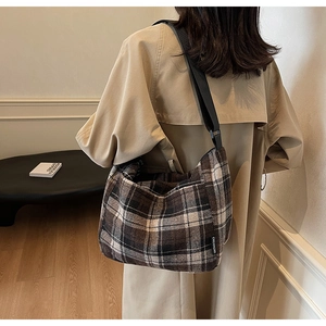 Borsa hobo a quadri marrone e beige con tracolla regolabile indossata da una modella