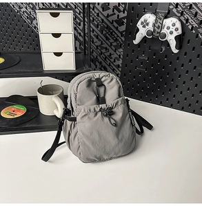 Détail du sac bandoulière en nylon gris imperméable avec mousqueton noir et cordon