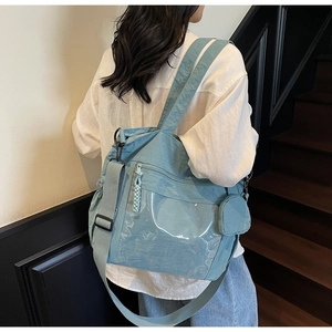 Close-up of blue nylon tote bag with transparent PVC pocket and side coin purse detail
