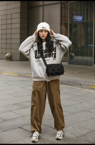 Street style outfit featuring a black messenger bag with a grey sweatshirt and cargo pants