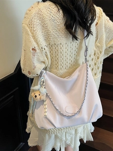 Minimalist beige hobo tote bag with pleated texture and bear charm accessory
