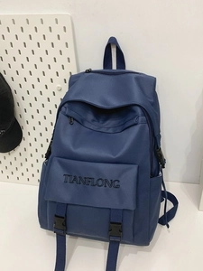 Dark blue minimalist canvas backpack with buckle straps and embroidery in a stylish aesthetic