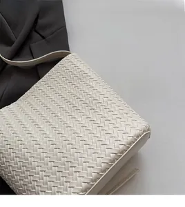 Detailed view of white woven leather texture on a stylish bucket shoulder bag