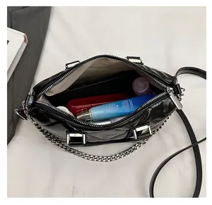 Top view of spacious interior of black quilted bag with chain and leather strap