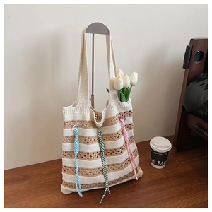 Detail of beige and brown striped knitted tote bag with colorful braided rope accents