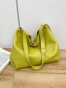 Minimalist bright lime green leather tote bag with pebble grain texture and wide strap