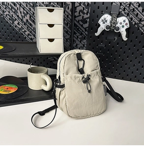 Détail du sac bandoulière en nylon imperméable avec poche avant à cordon et mousqueton