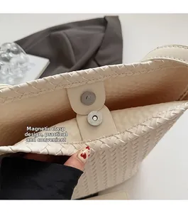 Close-up of woven tote bag showing the magnetic buckle closure and textured finish