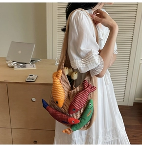 Detail of knit tote bag with colorful cartoon fish pendants in a cozy home setting