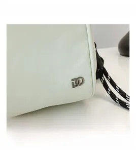Detail shot of beige shell bag featuring fabric texture and silver-tone metal double-D logo