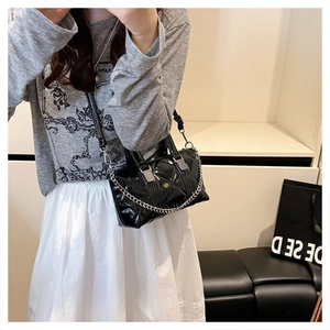 Close-up of black quilted leather pillow bag with silver chain and metal hardware