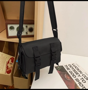 Detail of waterproof nylon messenger bag with double buckle closure on a retro shelf