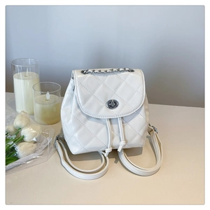 White quilted mini backpack featuring silver chain handle and drawstring closure detail