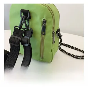 Close-up of smooth rear zipper and durable nylon fabric on a light green crossbody bag