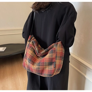 Dettaglio borsa vintage in tela a quadri con etichetta tessuta e tracolla nera resistente