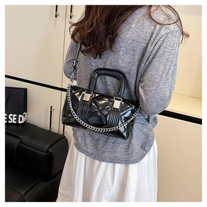 Close-up of black quilted hobo bag with glossy finish and silver chain decoration