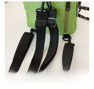 Detail view of the adjustable black nylon shoulder strap and buckle on a green shell bag